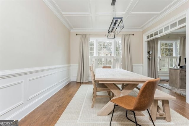 dining area with crown molding, coffered ceiling, and light hardwood / wood-style flooring