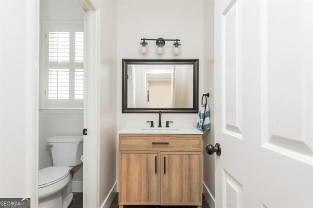 bathroom with vanity, a healthy amount of sunlight, and toilet