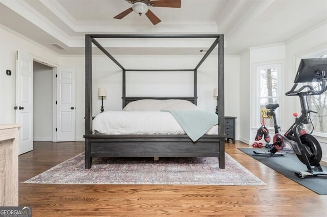 bedroom featuring crown molding, dark wood-type flooring, and ceiling fan