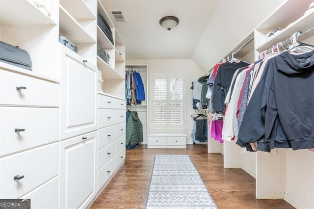 walk in closet with lofted ceiling and hardwood / wood-style flooring