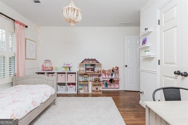 bedroom with dark hardwood / wood-style flooring and an inviting chandelier