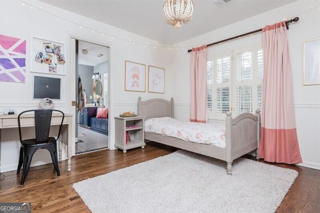 bedroom with vaulted ceiling, dark wood-type flooring, and an inviting chandelier