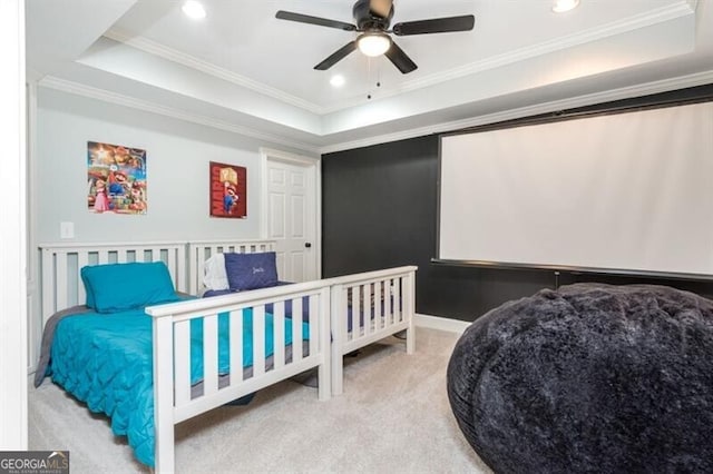 carpeted bedroom with ceiling fan, ornamental molding, and a raised ceiling