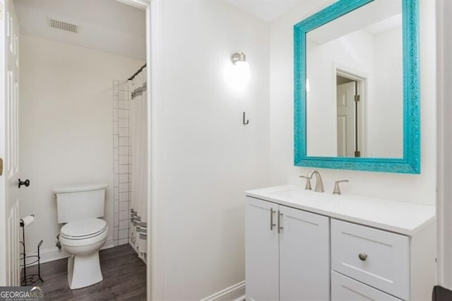 full bathroom with hardwood / wood-style flooring, vanity, toilet, and tiled shower / bath combo