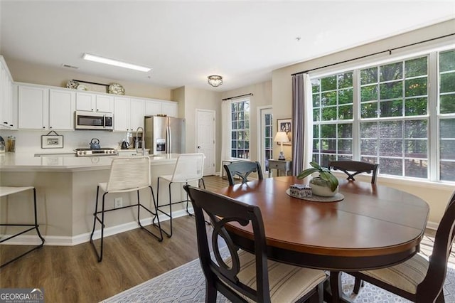 dining space with dark hardwood / wood-style flooring