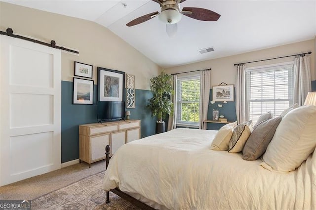 carpeted bedroom featuring lofted ceiling, a barn door, and ceiling fan