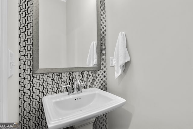 bathroom with tasteful backsplash and sink