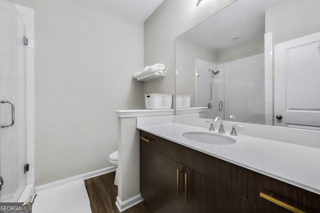 bathroom with walk in shower, vanity, toilet, and hardwood / wood-style floors