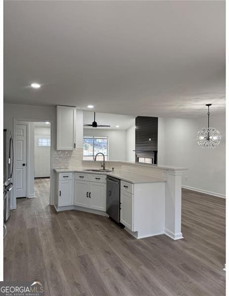 kitchen with pendant lighting, sink, stainless steel appliances, wood-type flooring, and white cabinets