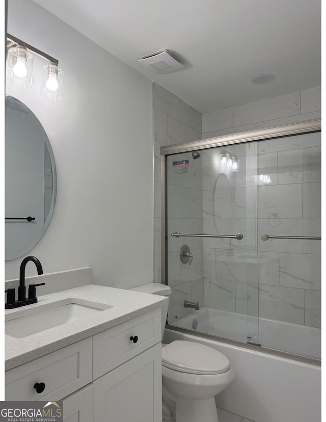 full bathroom featuring toilet, vanity, shower / bath combination with glass door, and tile patterned flooring