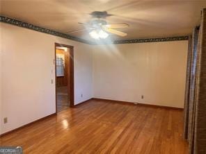 unfurnished room with wood-type flooring and ceiling fan