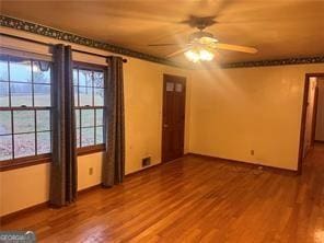 empty room featuring wood-type flooring, plenty of natural light, and ceiling fan