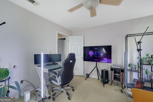 office area featuring light carpet, baseboards, visible vents, and a ceiling fan