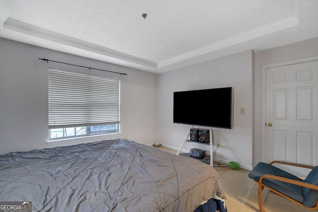 carpeted bedroom with a textured ceiling, a tray ceiling, and baseboards