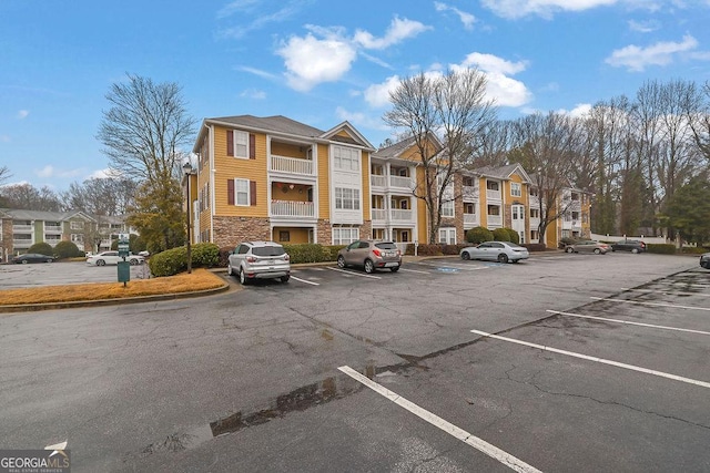 view of building exterior with uncovered parking and a residential view