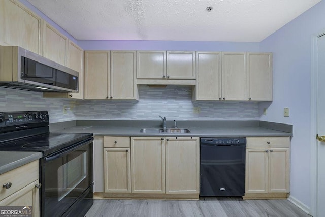 kitchen with black appliances, backsplash, dark countertops, and a sink