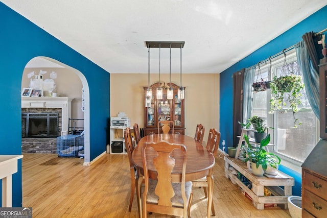 dining space featuring hardwood / wood-style flooring and a fireplace