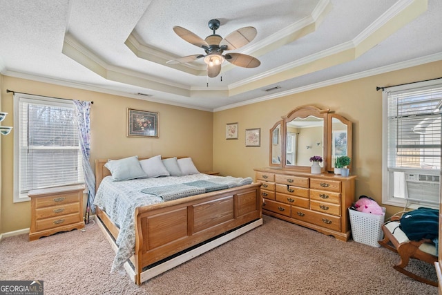 bedroom featuring crown molding, a tray ceiling, carpet floors, and a textured ceiling