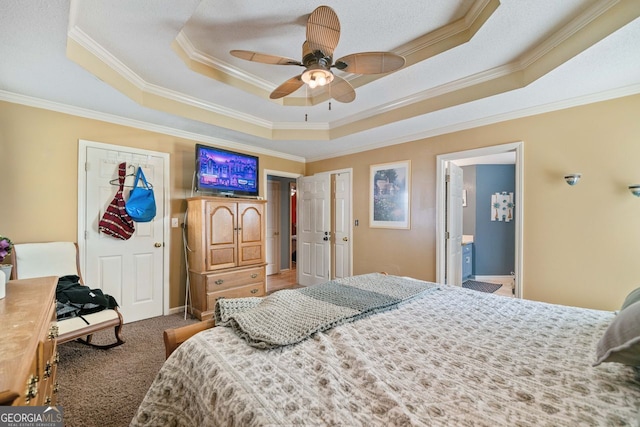 carpeted bedroom featuring ensuite bathroom, ornamental molding, and a raised ceiling