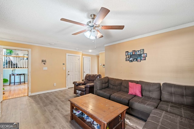 living room featuring ceiling fan, hardwood / wood-style flooring, ornamental molding, and a textured ceiling