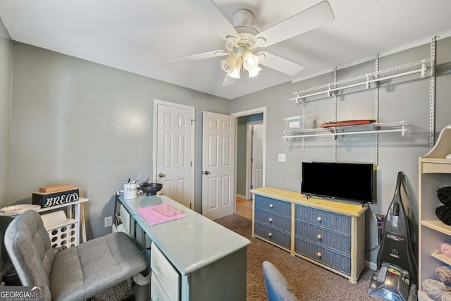 carpeted home office with ceiling fan