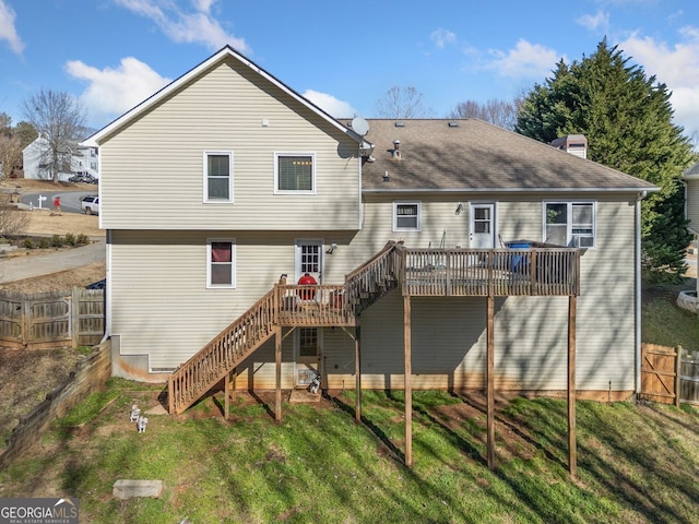 back of property featuring a wooden deck and a lawn