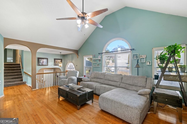 living room featuring hardwood / wood-style flooring, ceiling fan, and high vaulted ceiling