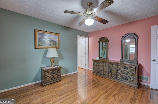 interior space with ceiling fan, light hardwood / wood-style flooring, and a textured ceiling