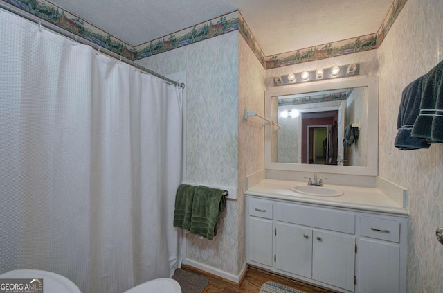 bathroom with hardwood / wood-style floors, vanity, toilet, a textured ceiling, and a shower with curtain