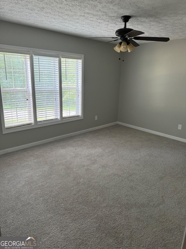 unfurnished room with ceiling fan, carpet, and a textured ceiling