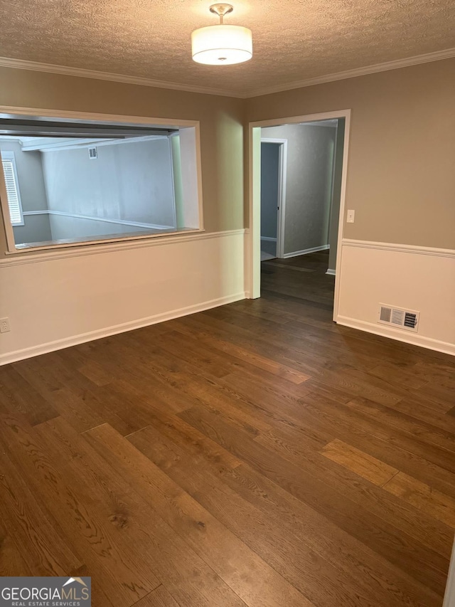 spare room with crown molding, dark hardwood / wood-style floors, and a textured ceiling