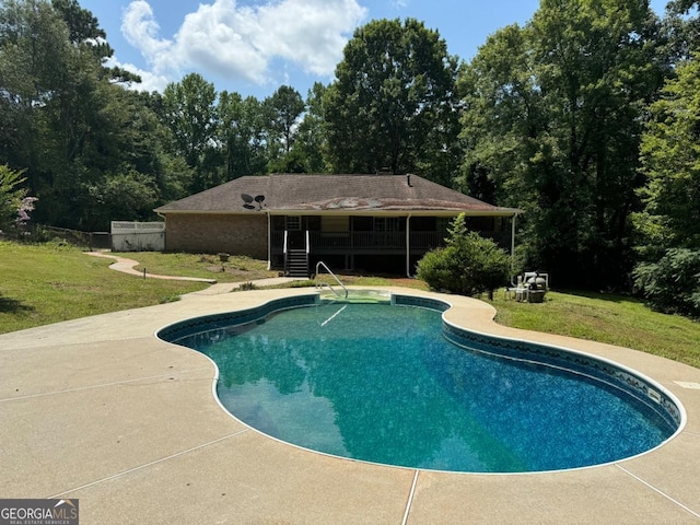 view of pool with a lawn