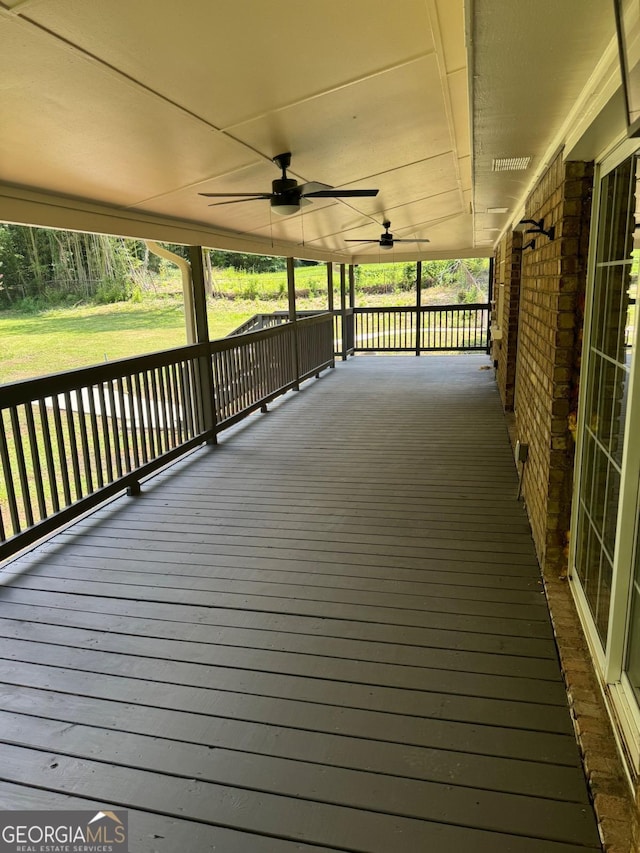 deck with ceiling fan and covered porch