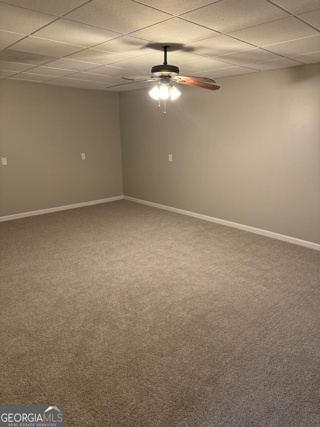 empty room with a paneled ceiling, ceiling fan, and carpet