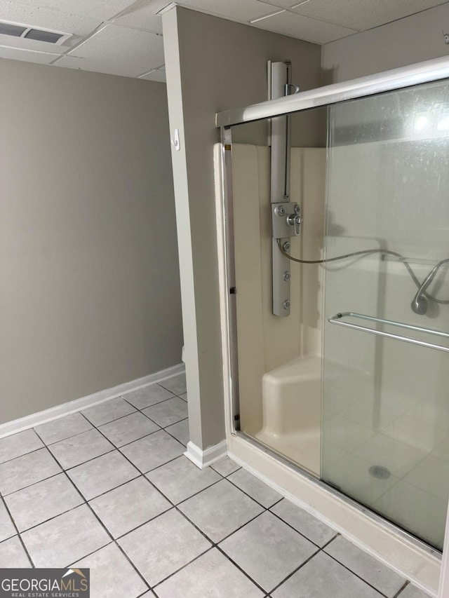 bathroom featuring walk in shower, tile patterned flooring, and a drop ceiling