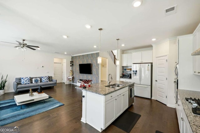 kitchen featuring stainless steel appliances, a kitchen island with sink, sink, and white cabinets