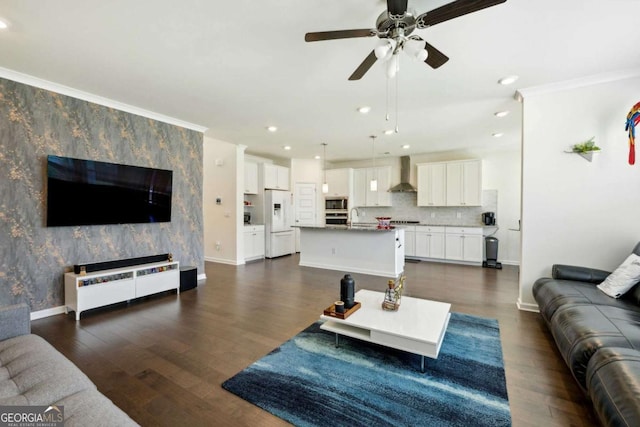 living room featuring crown molding, ceiling fan, dark hardwood / wood-style flooring, and sink