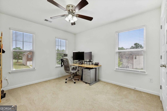 carpeted home office featuring ceiling fan