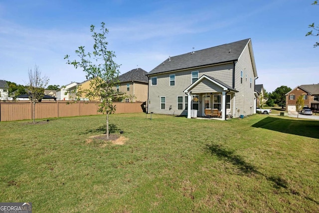 rear view of house with a patio and a yard