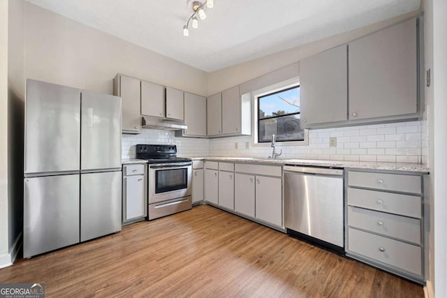 kitchen featuring sink, gray cabinets, light hardwood / wood-style floors, and appliances with stainless steel finishes