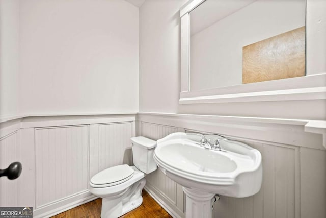 bathroom featuring hardwood / wood-style flooring and toilet