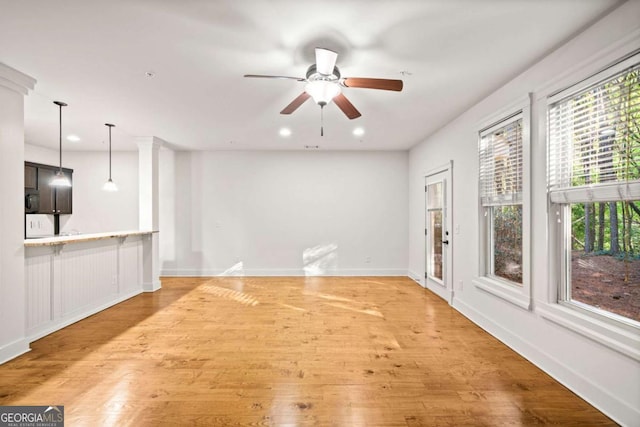 unfurnished living room featuring hardwood / wood-style flooring and ceiling fan