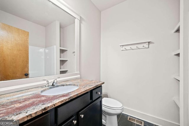 bathroom featuring vanity, walk in shower, tile patterned floors, and toilet