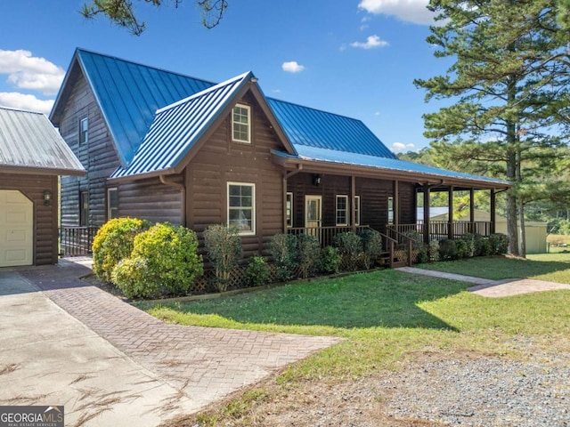 log cabin featuring covered porch and a front yard