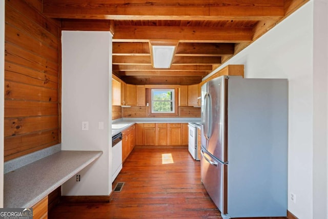 kitchen featuring dark wood-type flooring, wood ceiling, light brown cabinets, white appliances, and beam ceiling