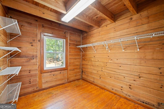 walk in closet with light wood-type flooring and beam ceiling