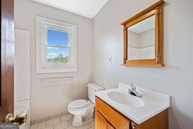 bathroom with tile patterned floors, vanity, toilet, and a shower