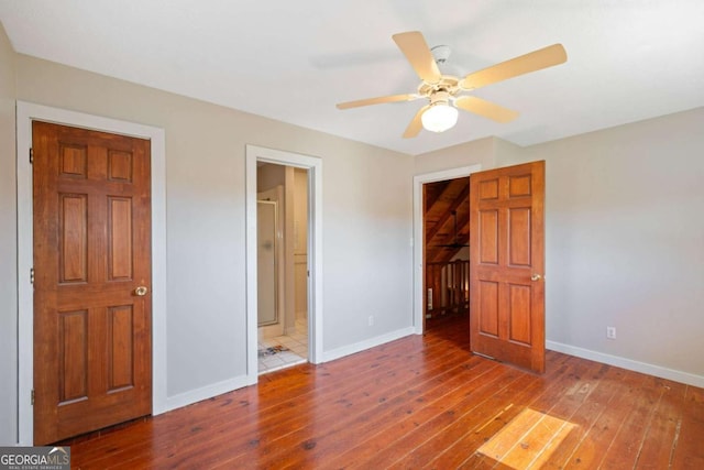 unfurnished bedroom with connected bathroom, hardwood / wood-style flooring, and ceiling fan