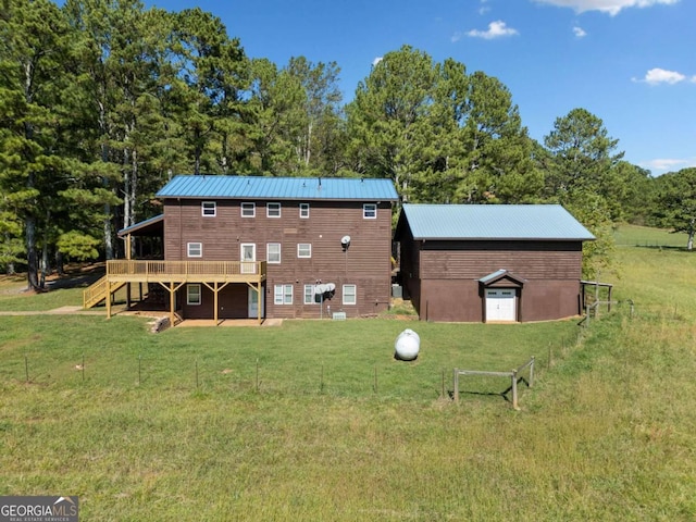 rear view of house featuring a yard and a deck