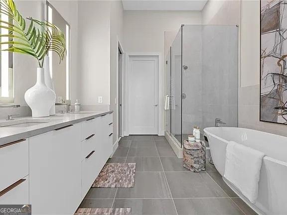 bathroom featuring independent shower and bath, vanity, and tile patterned flooring